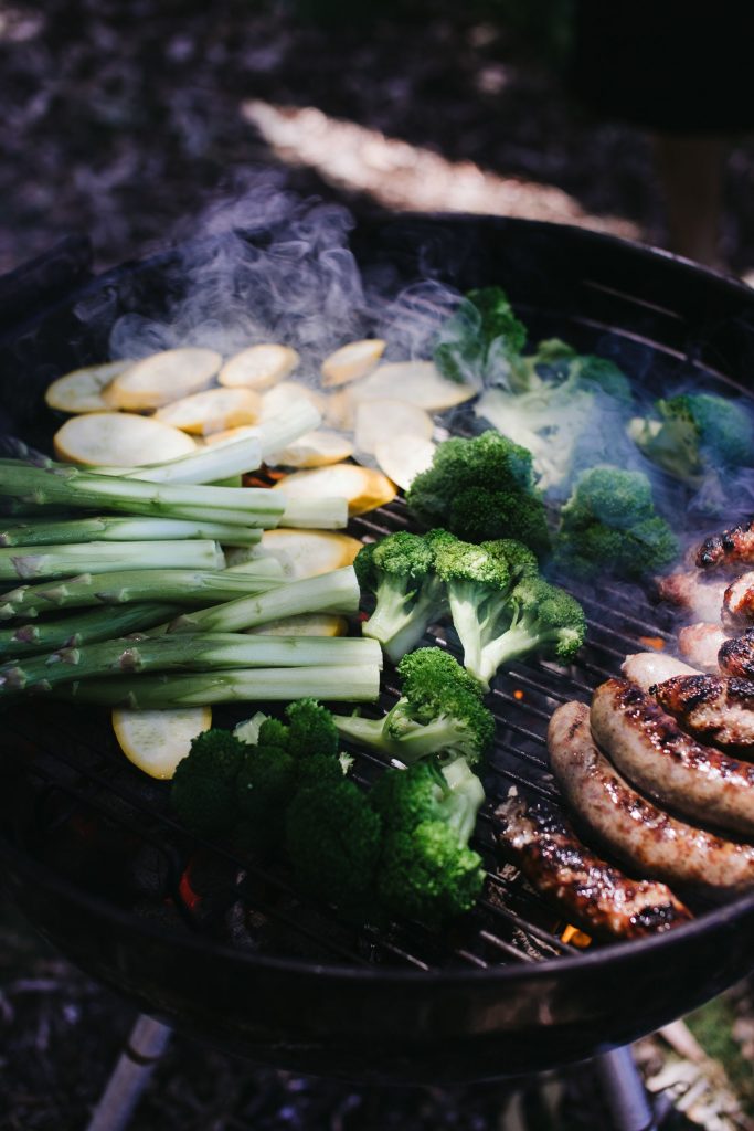 Vegetables and sausages on grill