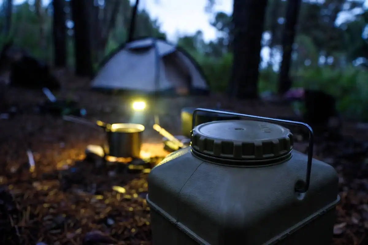 bear canister stored far from tent in forest at twilight