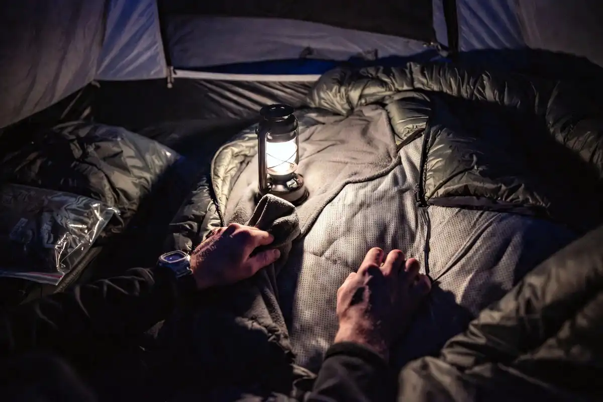camper adding dry layer to stay warm when humidity makes gear damp