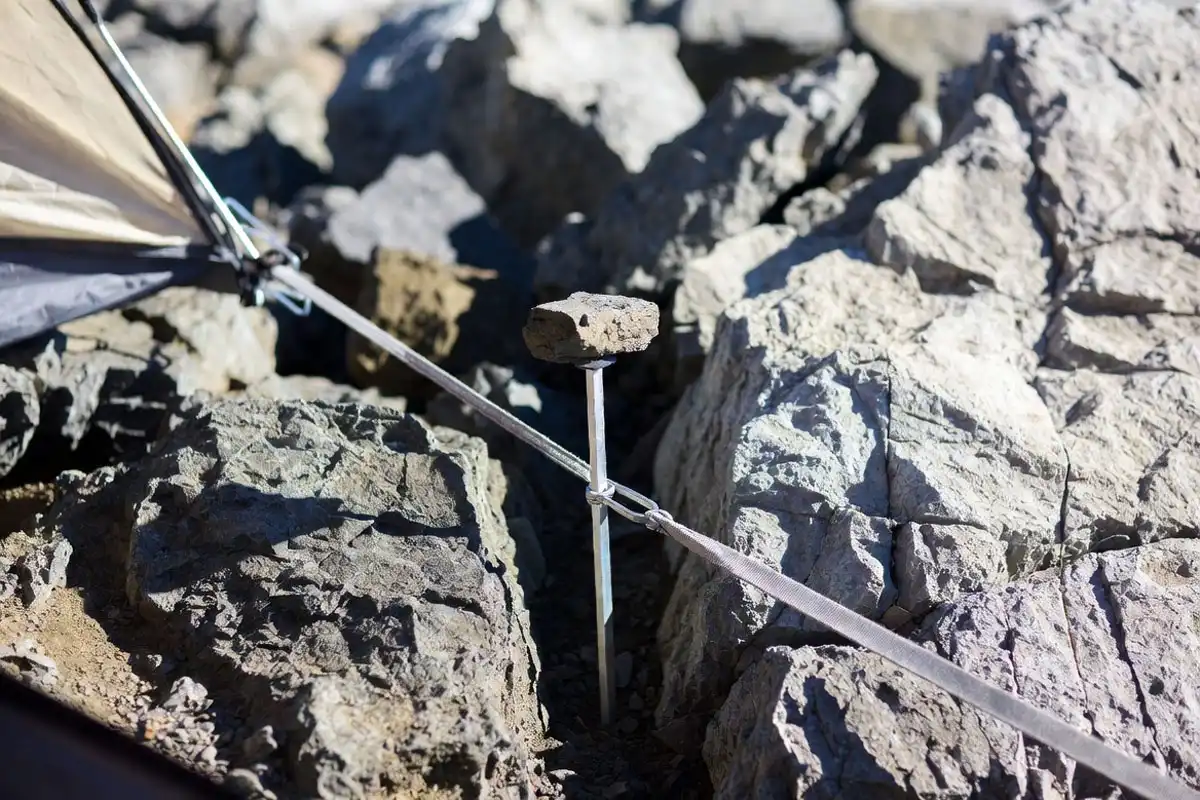 stake set in crack with rock on top