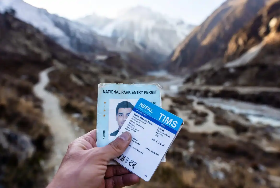 hiker holding Nepal TIMS card and conservation area trekking permit on trail