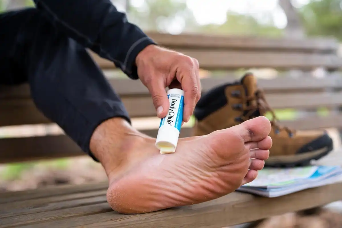 hiker applying anti chafe balm to heel before trail