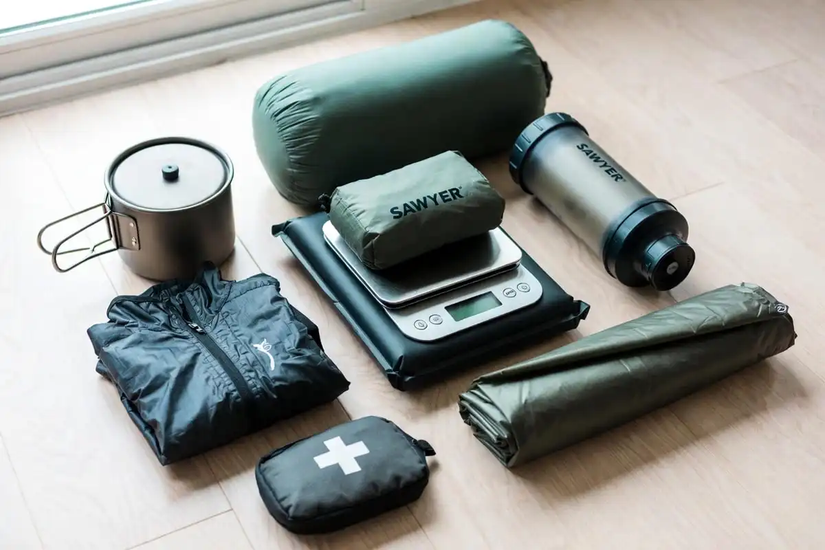ultralight backpacking gear arranged flat on wooden floor for weight check