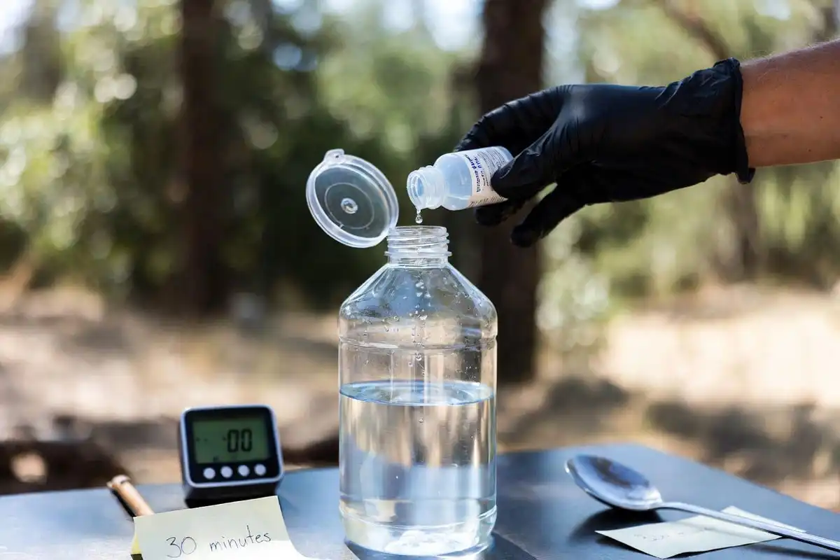 measured bleach drops added to a water bottle at camp