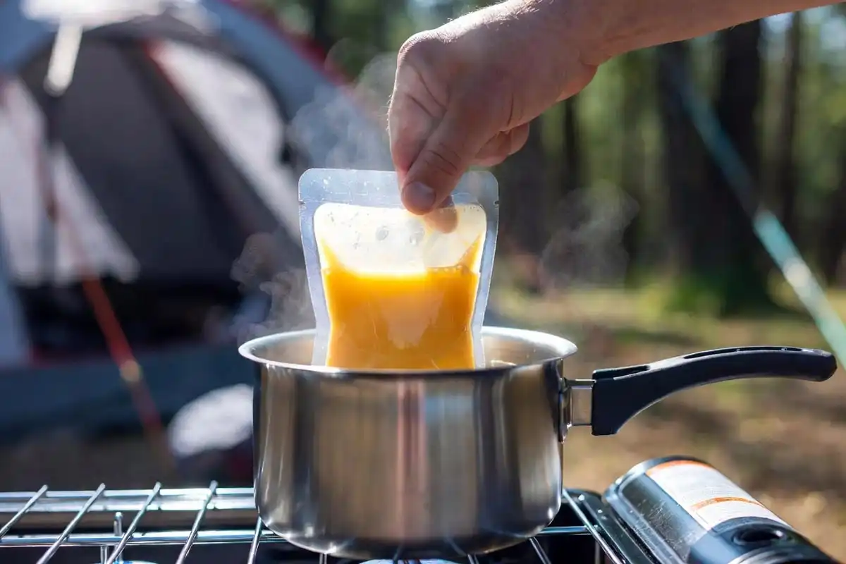 sealed bag with eggs submerged in boiling water at campsite