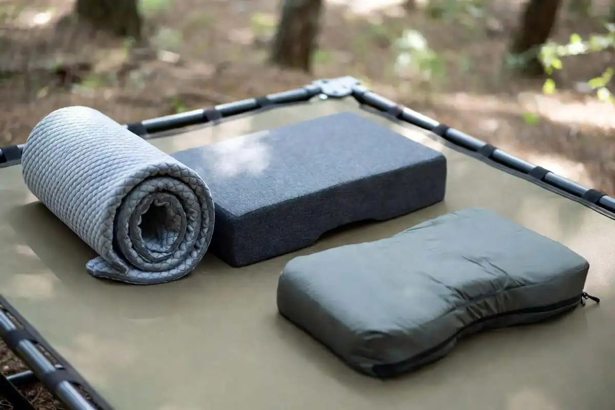 memory foam pad lumbar pillow and sleeping bag laid on camping cot