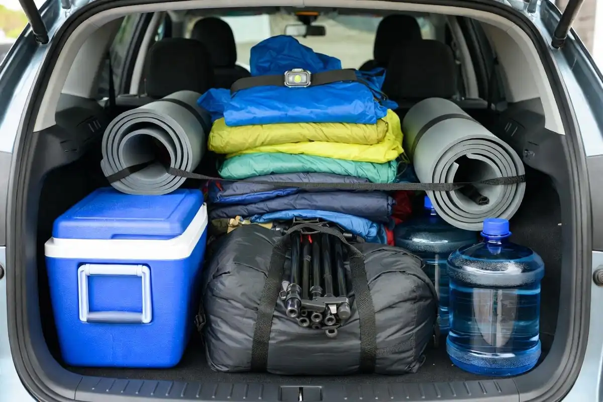 organized camping equipment loaded in car trunk by weight zones