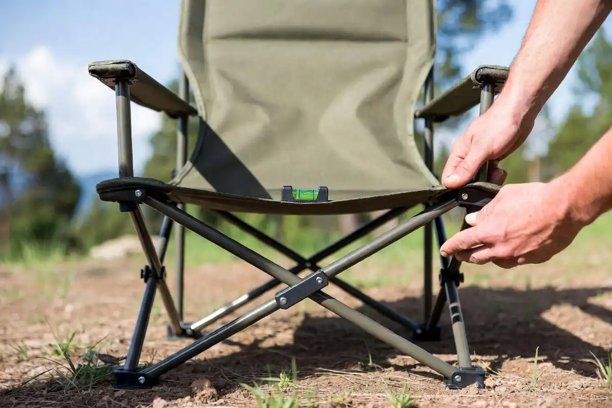 hands opening folding chair and checking lock on level ground