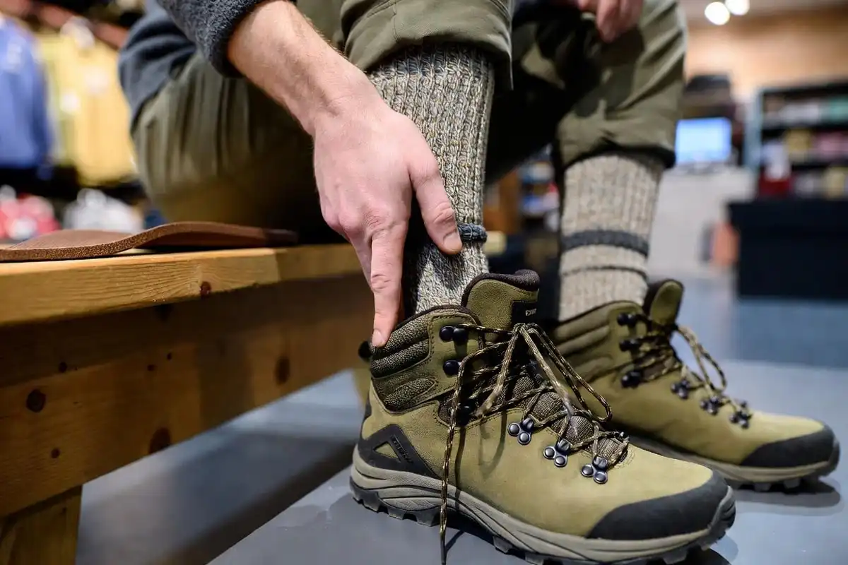 finger placed behind heel inside hiking boot to check fit