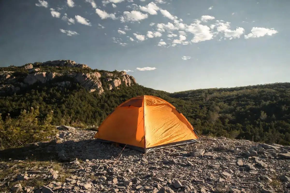tent pitched on elevated ridge above a forested valley with open airflow around campsite