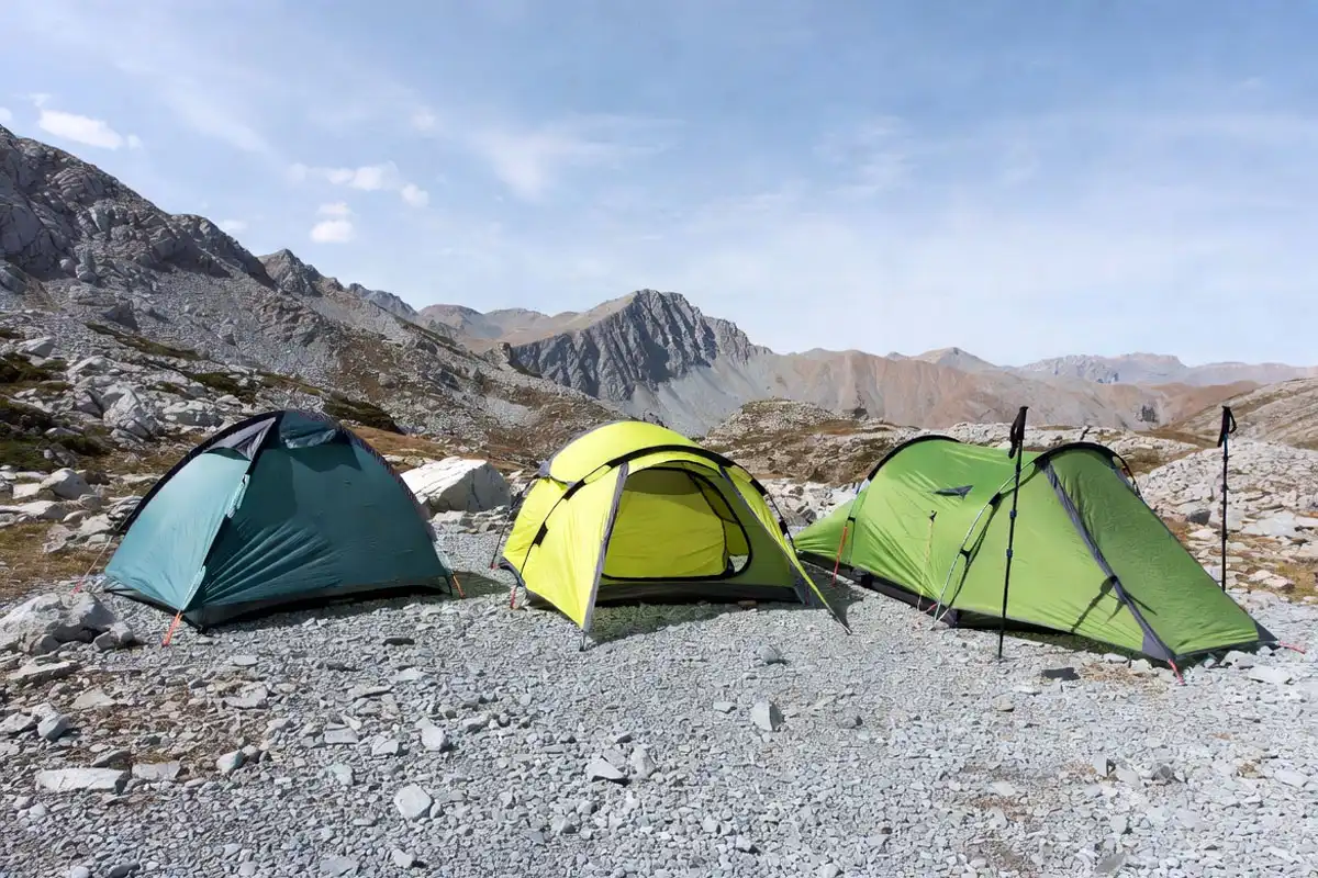 three tent types pitched side by side showing freestanding semi freestanding and trekking pole designs