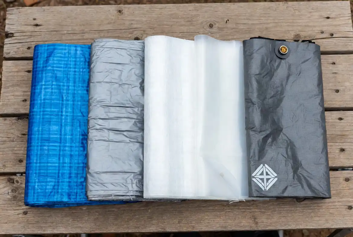 five types of ground cloth materials laid side by side on wooden surface