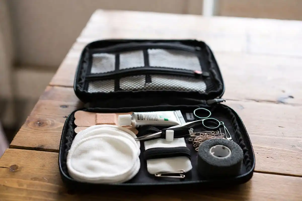 opened hiking first aid kit with bandages gauze and blister pads