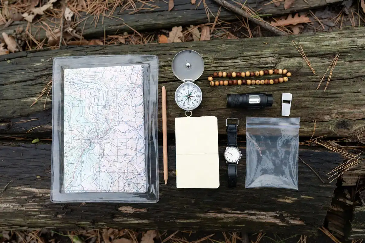 map compass headlamp and whistle laid out for hiking