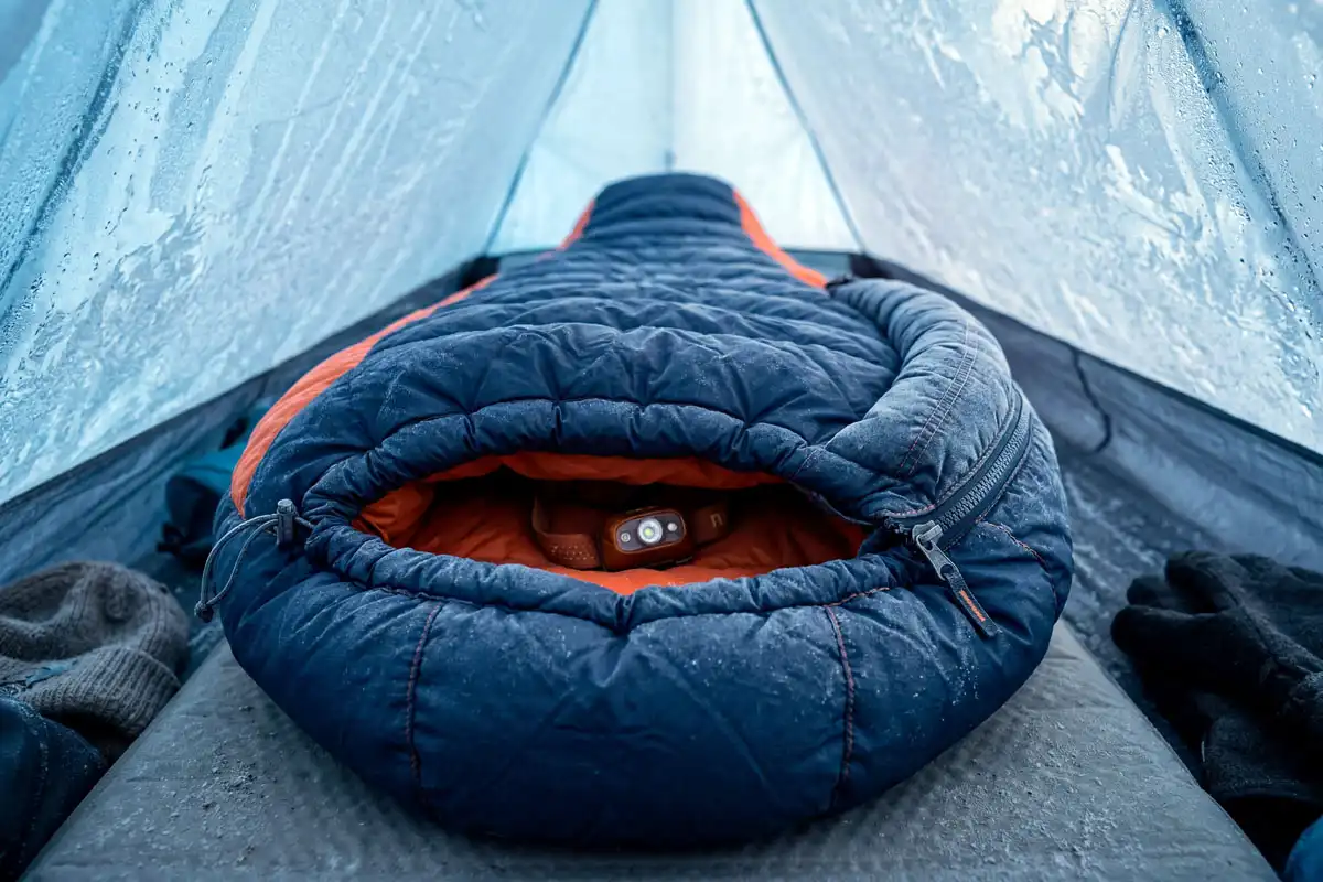 A mummy sleeping bag showing draft collar and zipper draft tube inside a tent