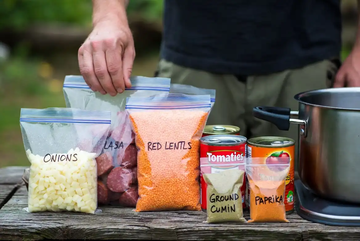 pre measured camping ingredients in labeled zip bags including lentils sausage and spices