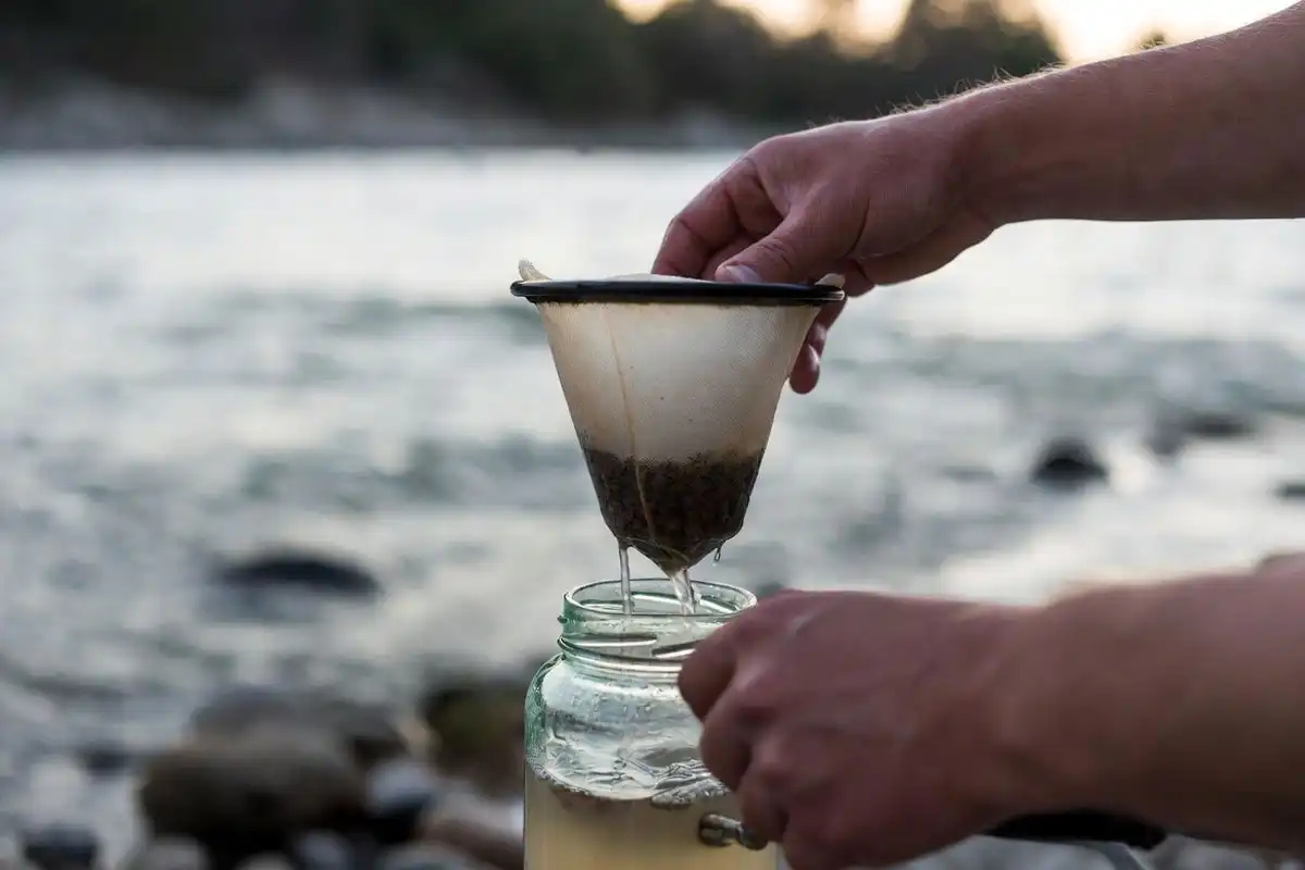 hands pouring cloudy water through a coffee filter