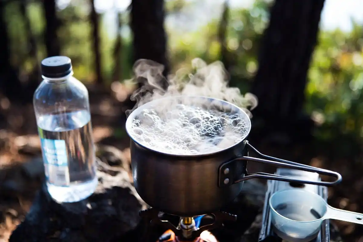 pot of water at a rolling boil on a camp stove