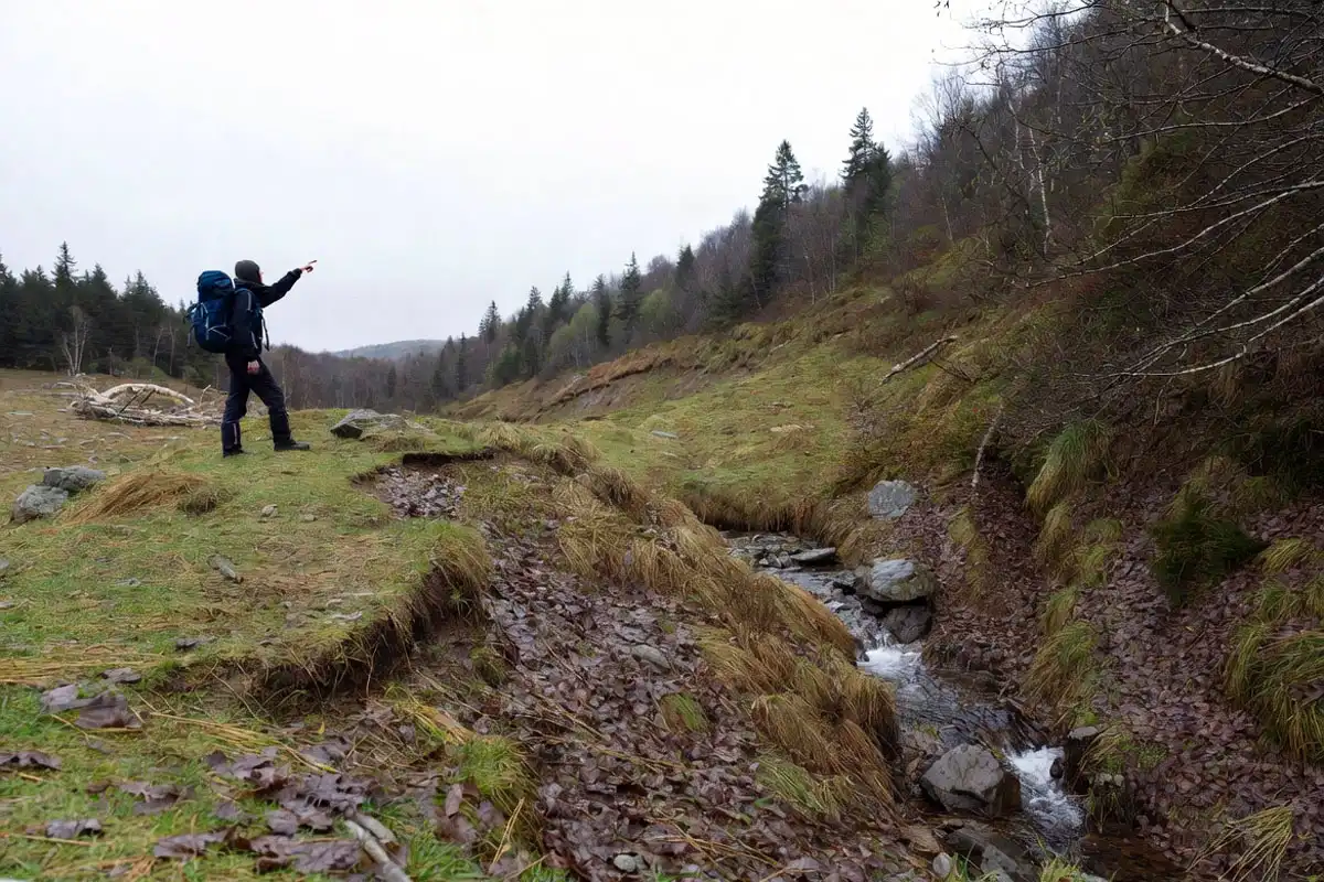 hiker choosing high ground above runoff line