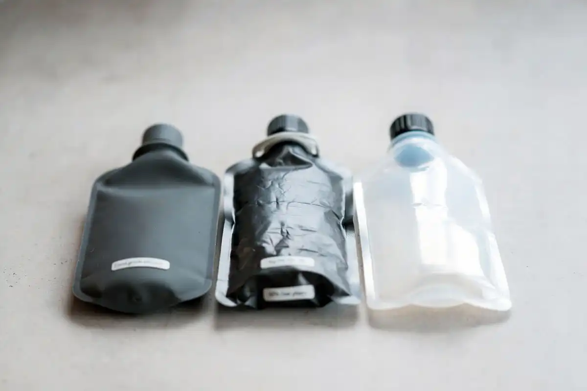 three travel water bottle materials silicone nylon and plastic film side by side