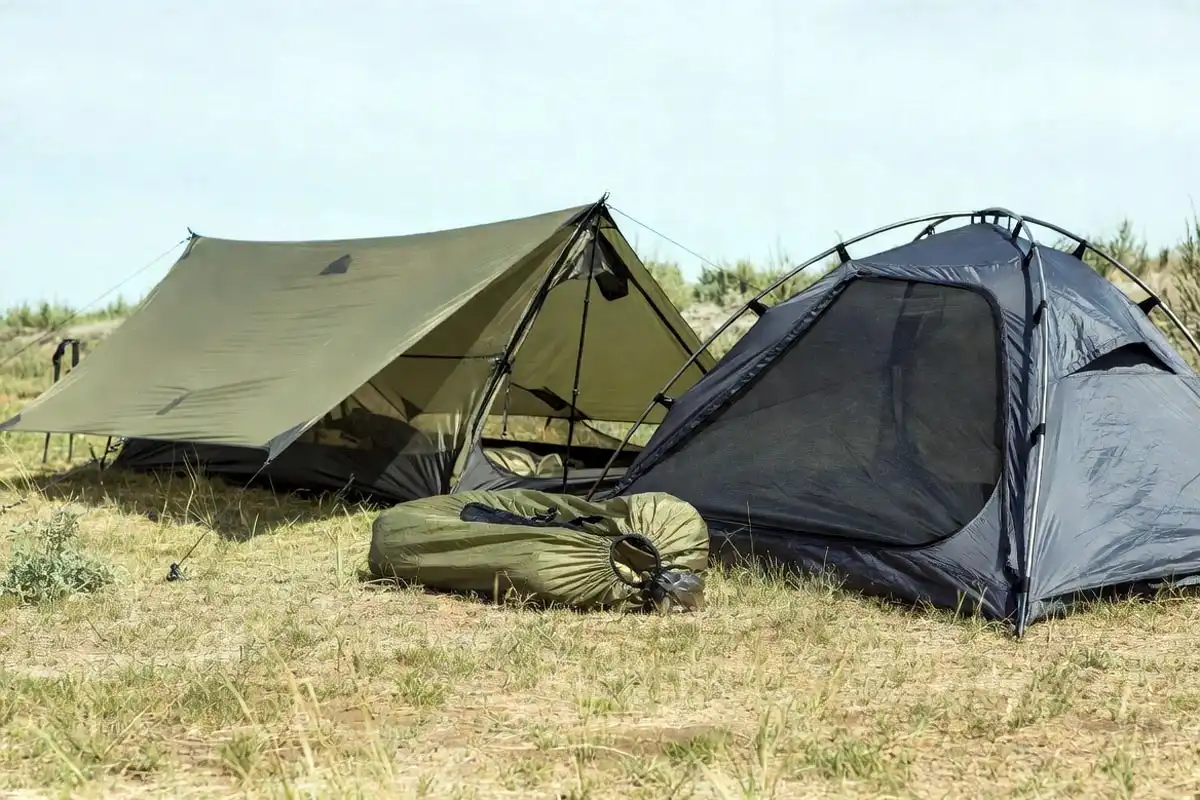 lightweight tarp bivy and single wall shelter options laid out on grass