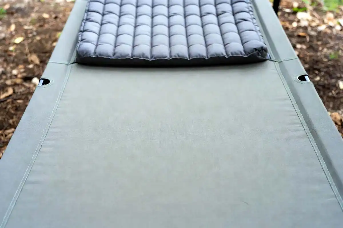 tightly stretched cot sleeping surface with foam pad on top