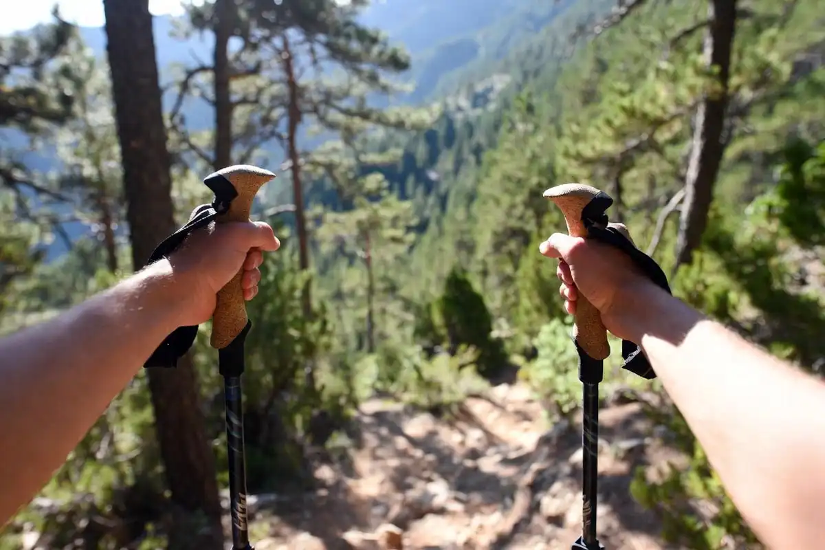 hiker using trekking poles correctly on a steep mountain ascent