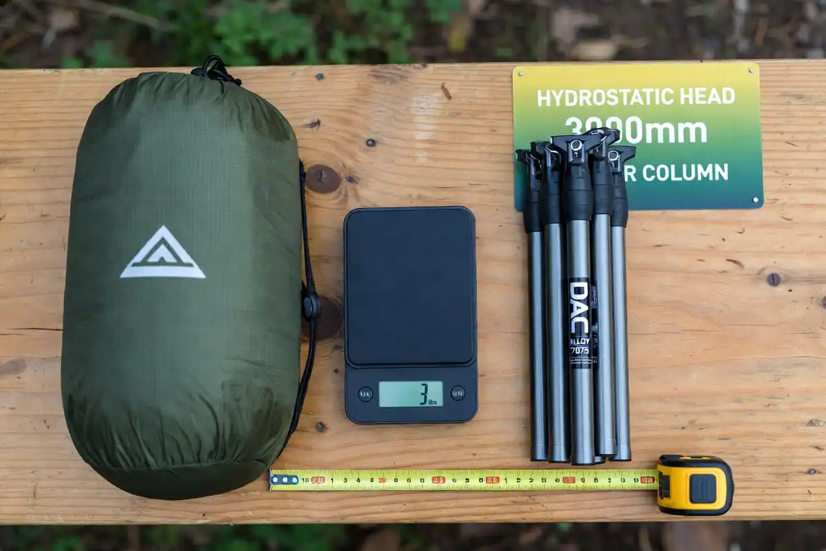 tent packed size on scale beside DAC poles and waterproof rating card