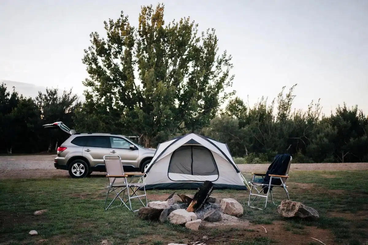 car camping setup next to a vehicle at a developed campground