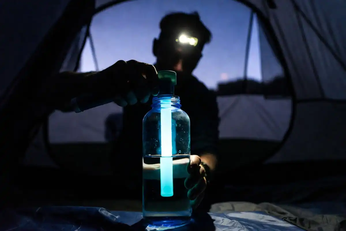 uv purifier wand treating clear water inside a tent vestibule