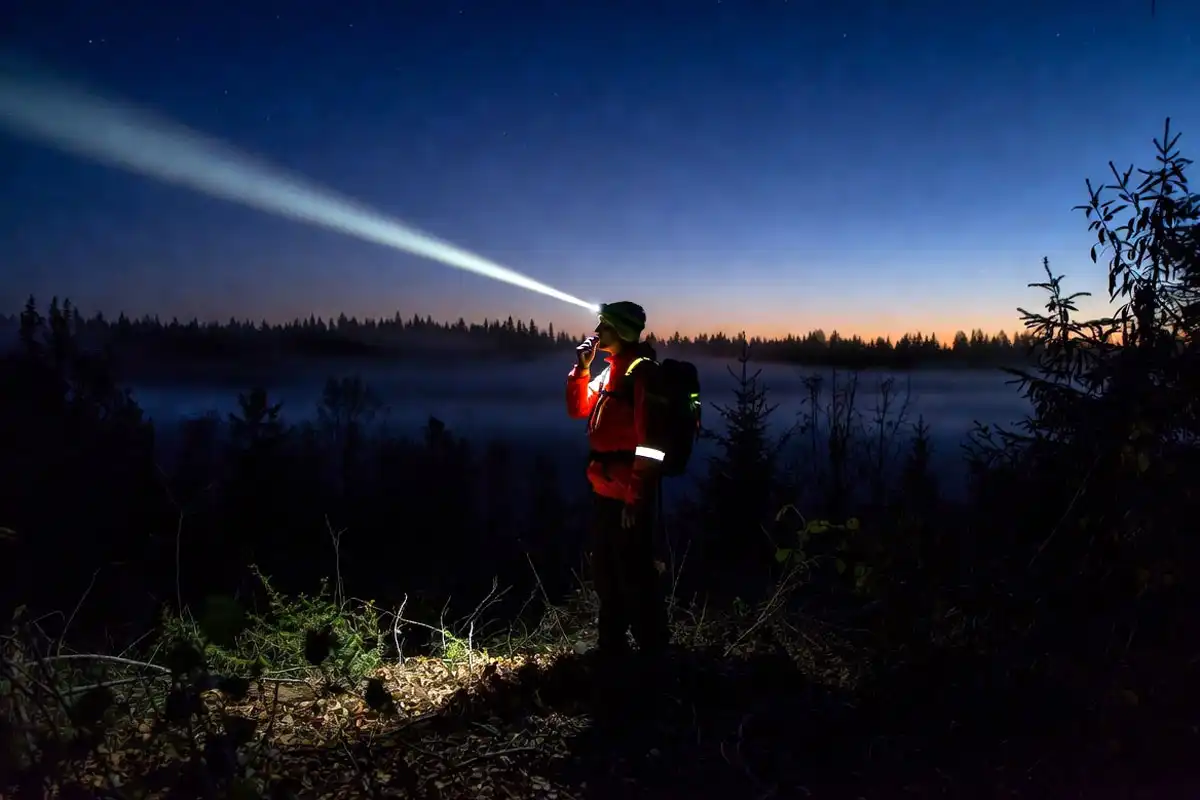 using a whistle and headlamp to signal in a clearing