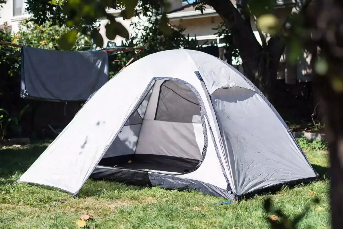 Clean camping tent set up in a shaded backyard drying after washing