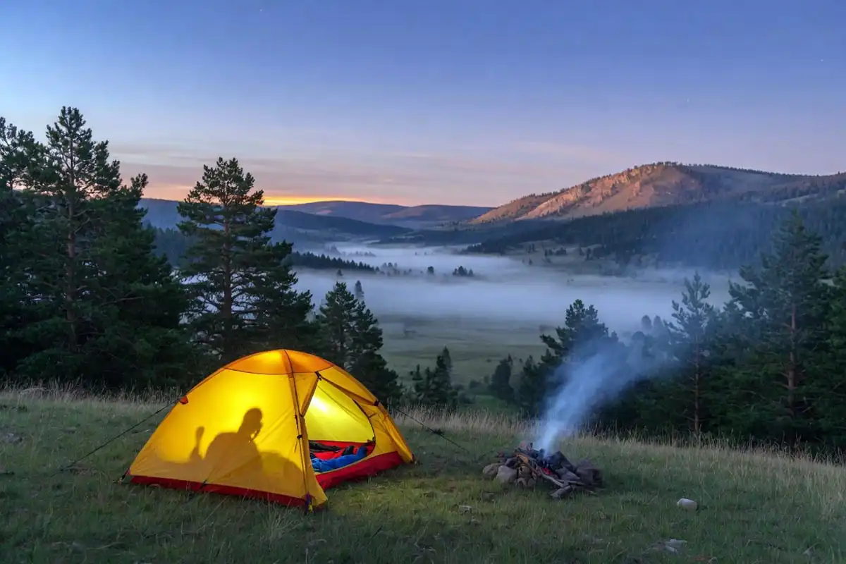 Tent pitched on ridge above valley for warmer sleep