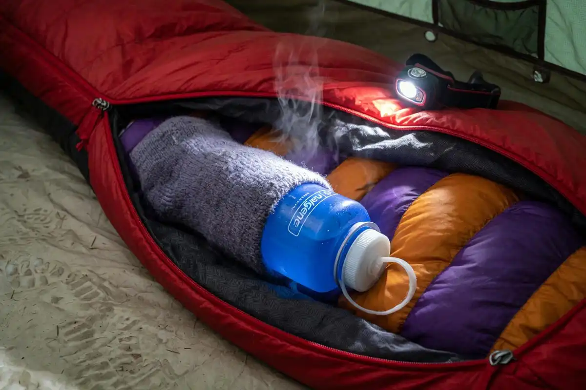 Nalgene hot water bottle placed inside sleeping bag for warmth