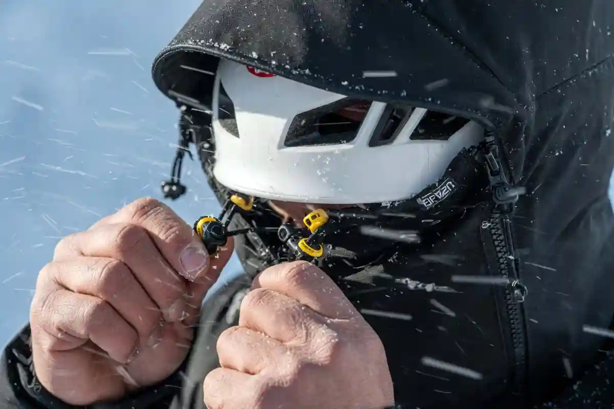 climber adjusting a helmet-compatible hood on a hardshell jacket