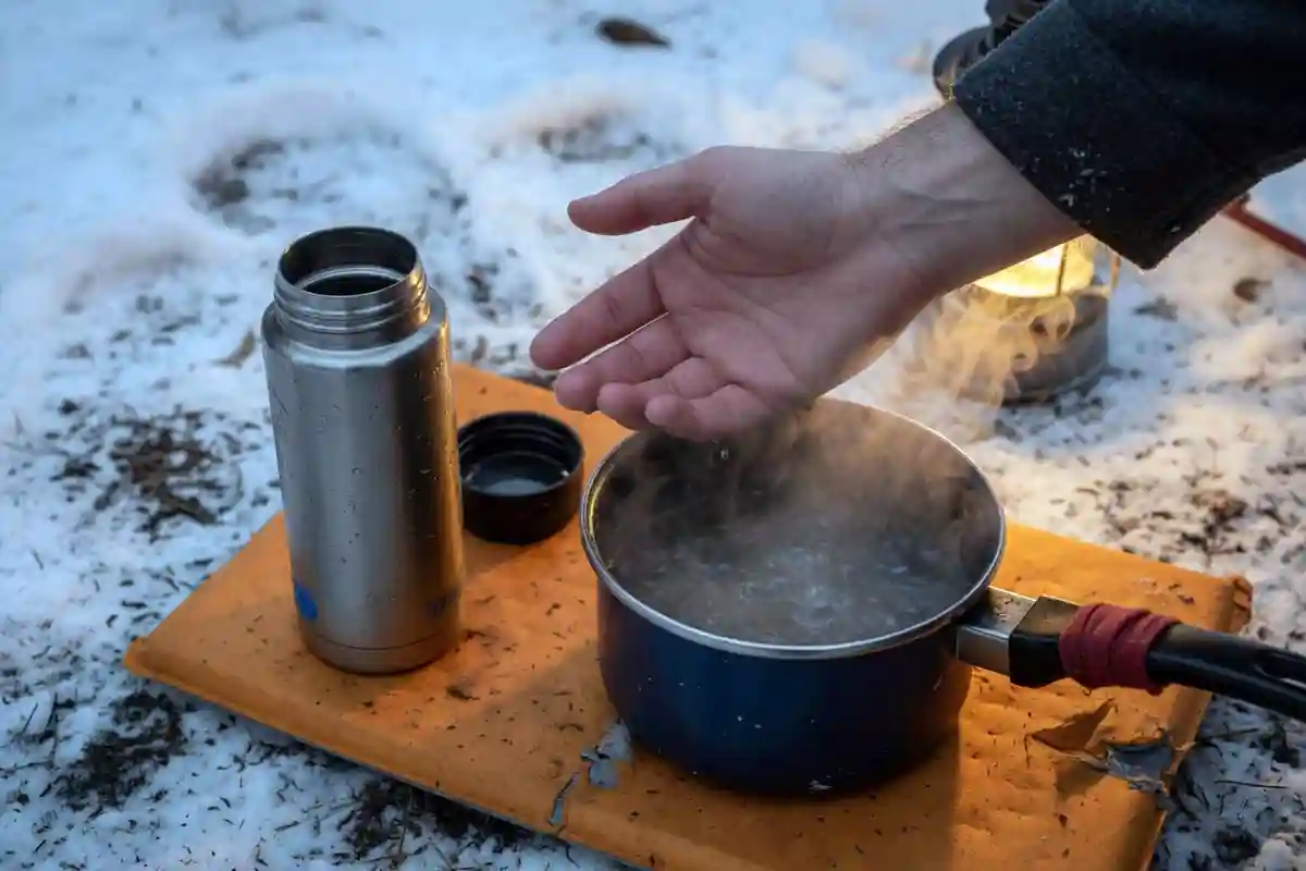Camper testing warm water temperature with wrist before washing