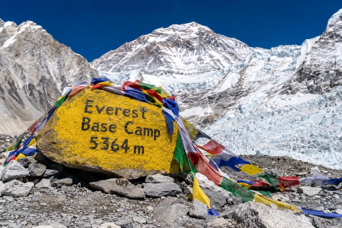 Everest Base Camp boulder with prayer flags at 5364 meters