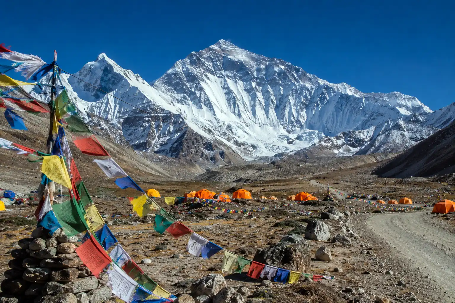 Mount Everest's north face seen from the Tibetan North Base Camp with colorful prayer flags strung in the foreground