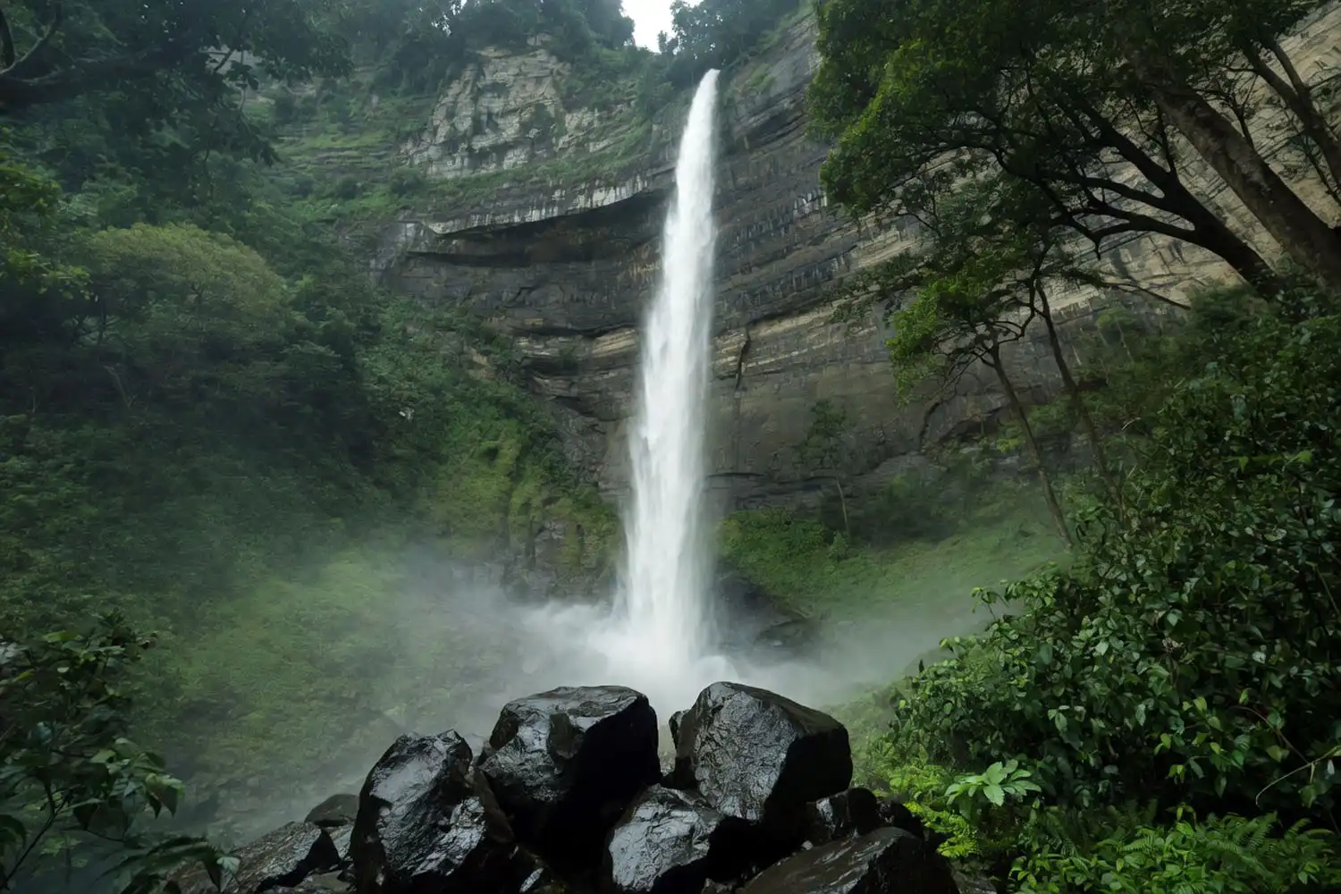 Langlok Waterfall cascading down a tall forested cliff in Bandarban Bangladesh during monsoon season