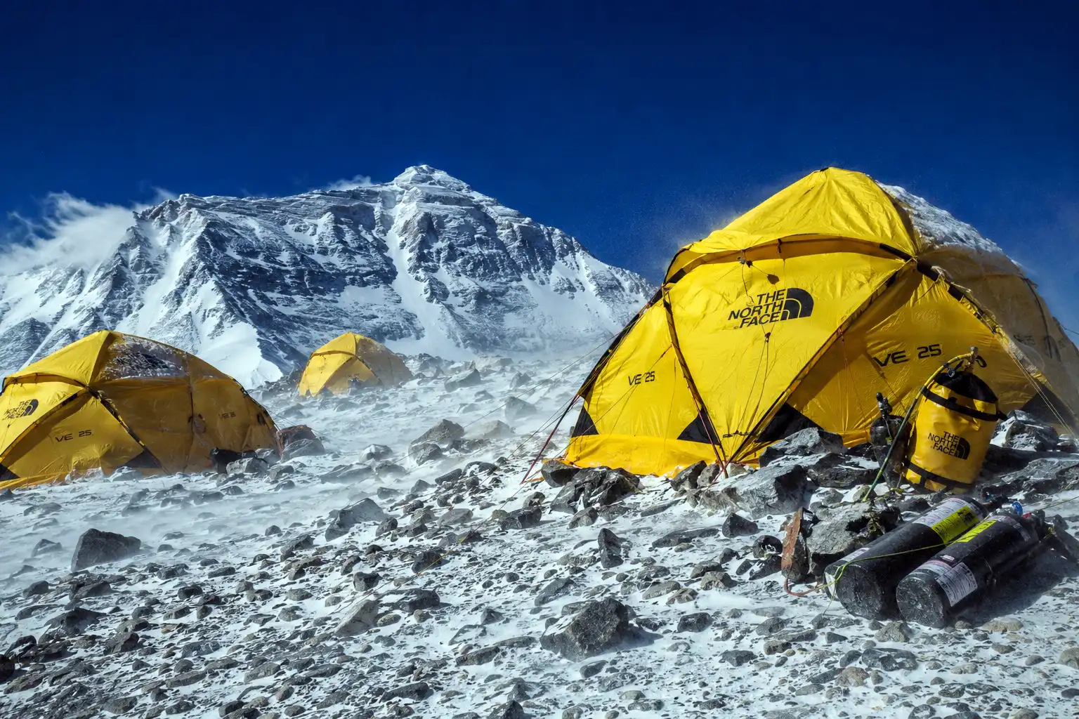 Yellow expedition tents pitched on the rocky windswept South Col of Mount Everest at Camp 4 in the Death Zone