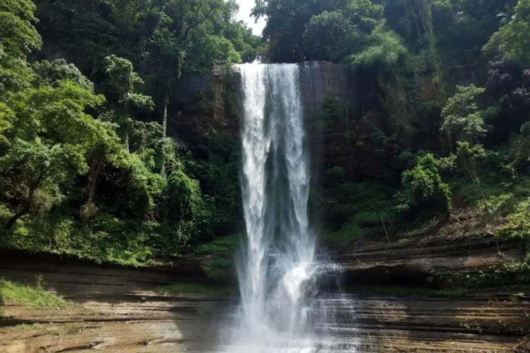 Tall white water cascade of Dhuppani Waterfall falling over dark rock in the green hills of Bilaichhari Rangamati