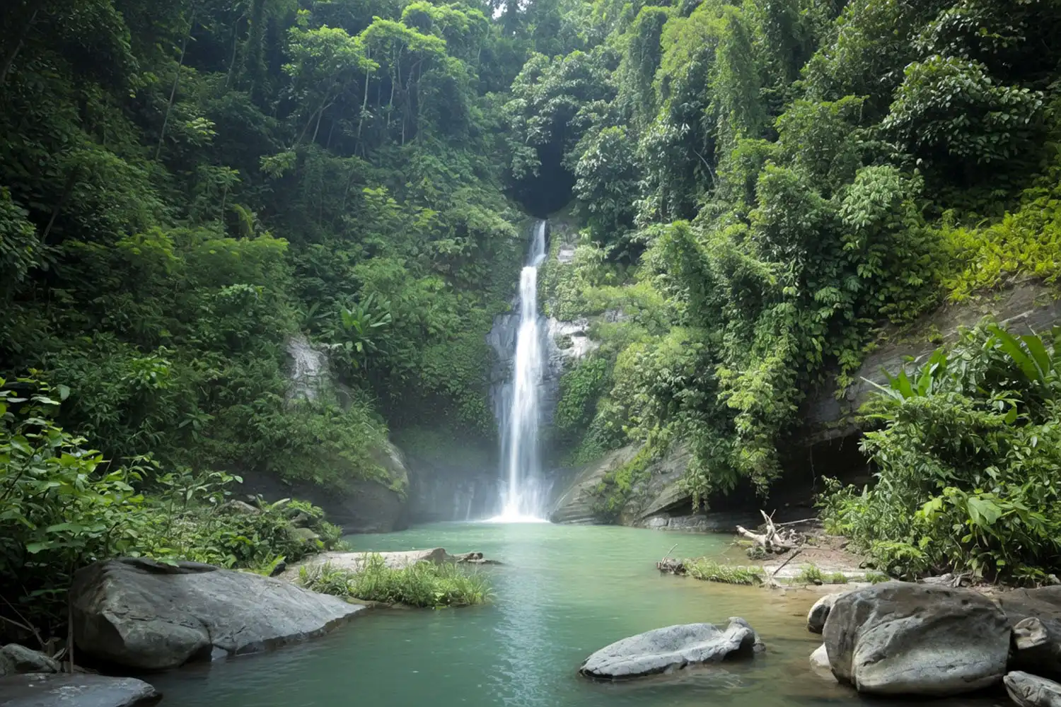 Thankowain Waterfall cascading into a clear natural pool surrounded by green forested hills in Alikadam, Bandarban