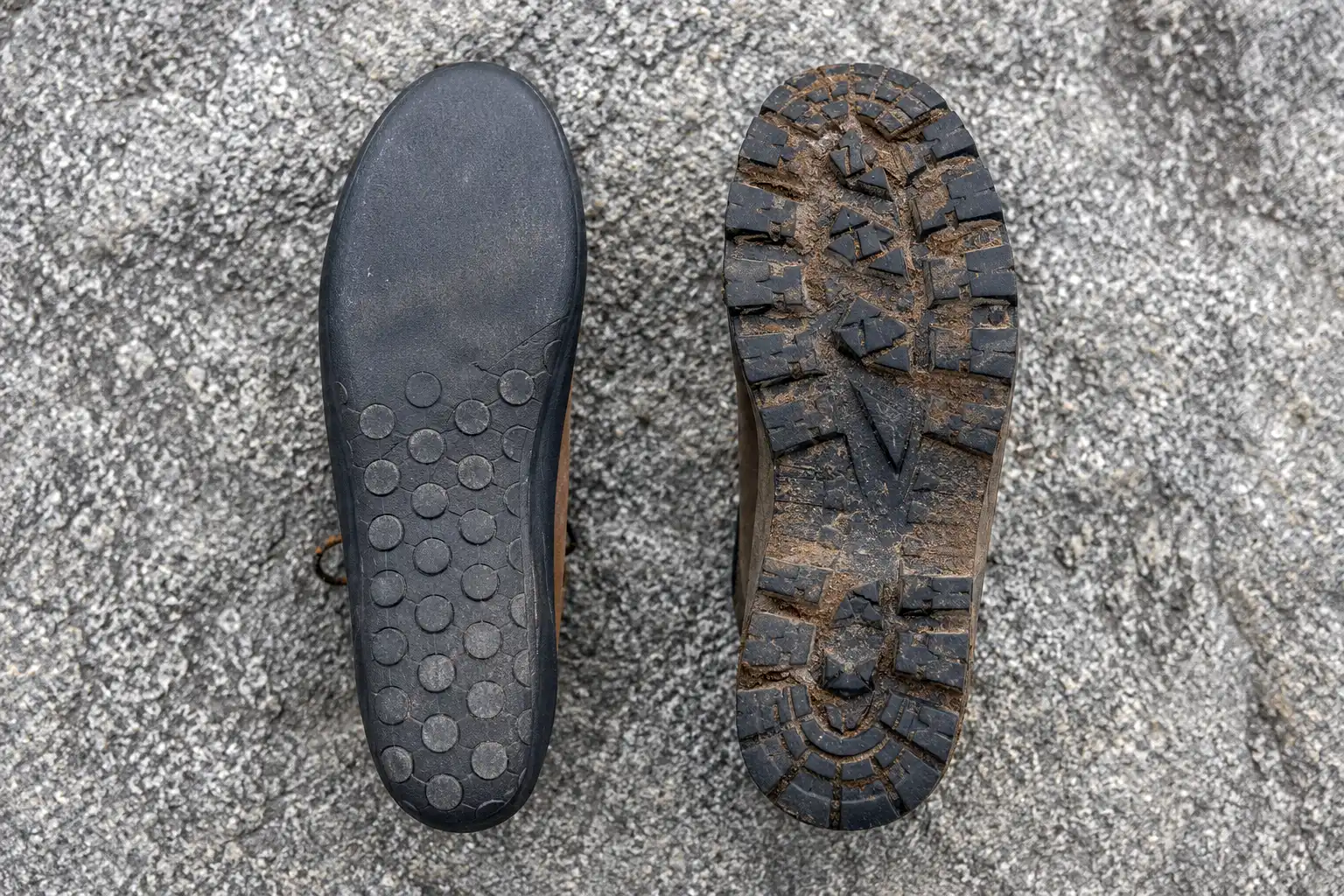 Overhead photo comparing an approach shoe outsole with a shallow smooth climbing zone next to a hiking boot outsole with deep lugs