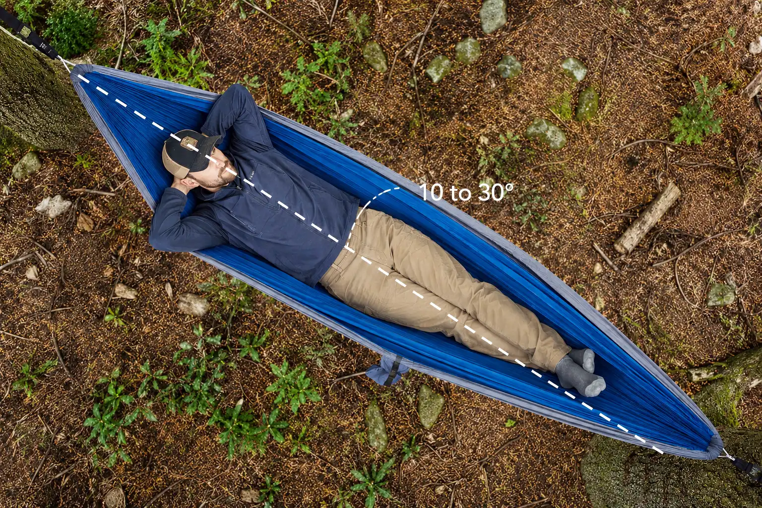 Overhead view of a camper lying diagonally across a hammock showing the angle that produces a flat back position