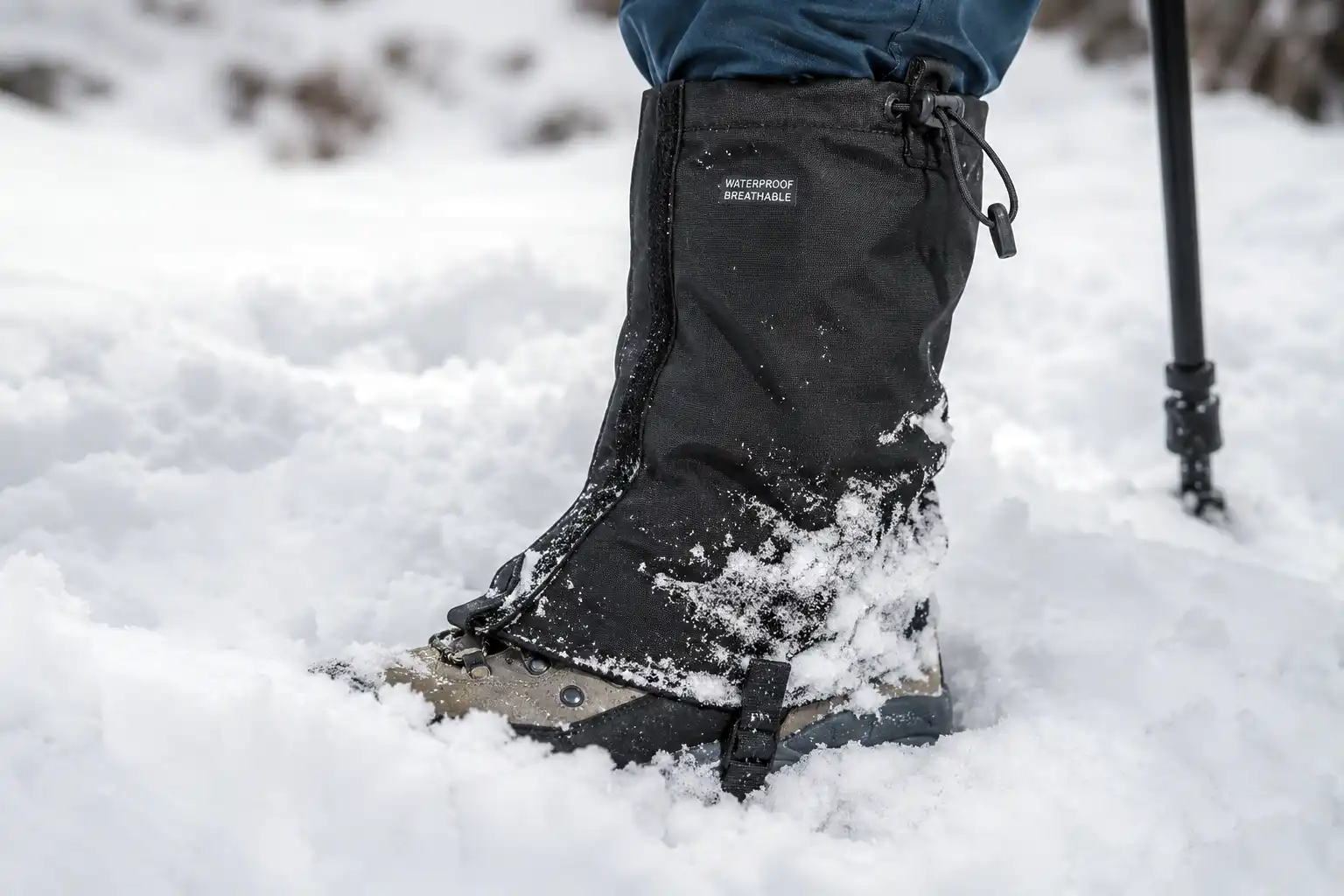 Waterproof gaiter fastened over a hiking boot and lower leg to block deep snow from entering the boot collar